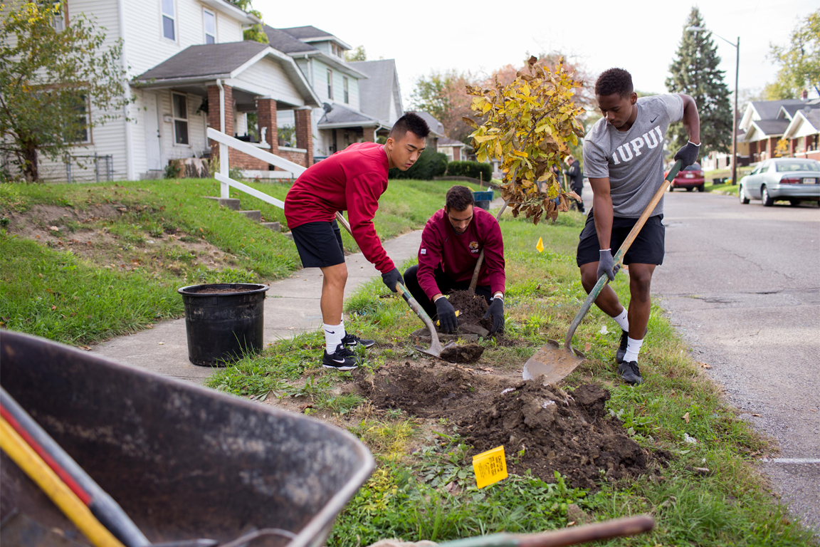 Students shoveling dirt as part of a community service activity.